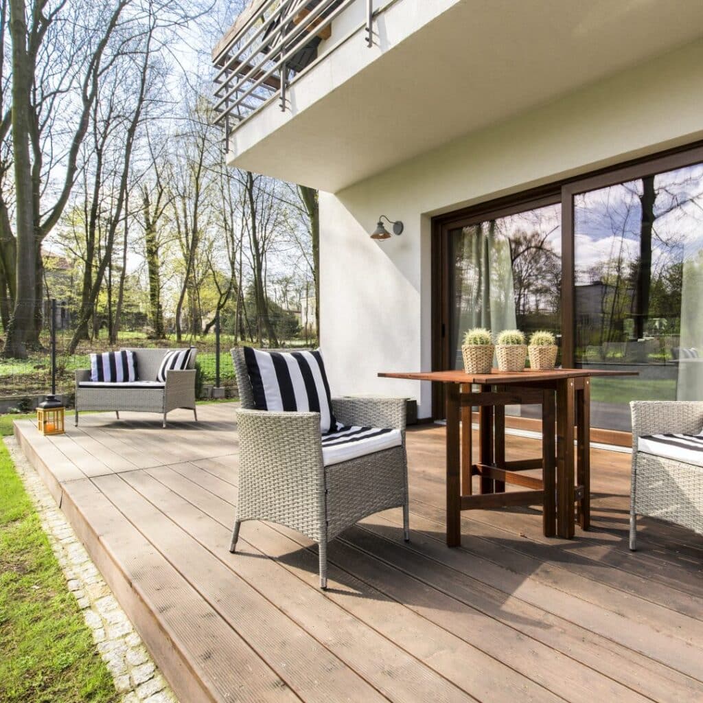 Moderne Terrasse mit stilvoller Sitzgruppe und Ausblick ins Grüne – einladendes Wohnambiente.